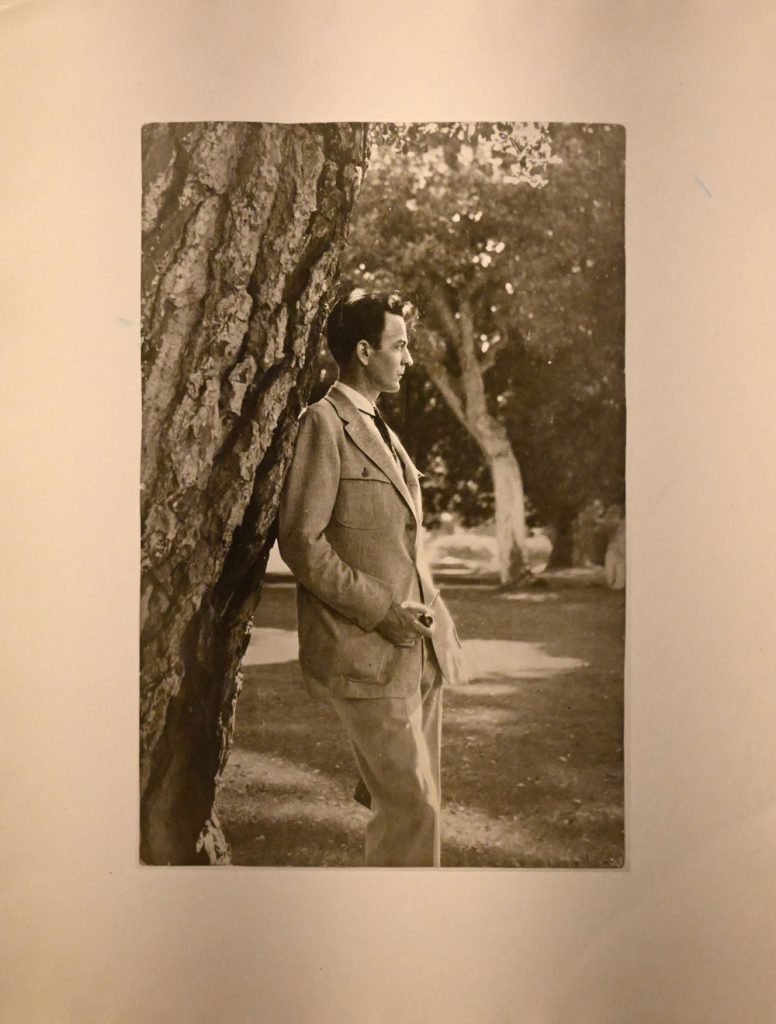 Raymond Chandler standing against a tree